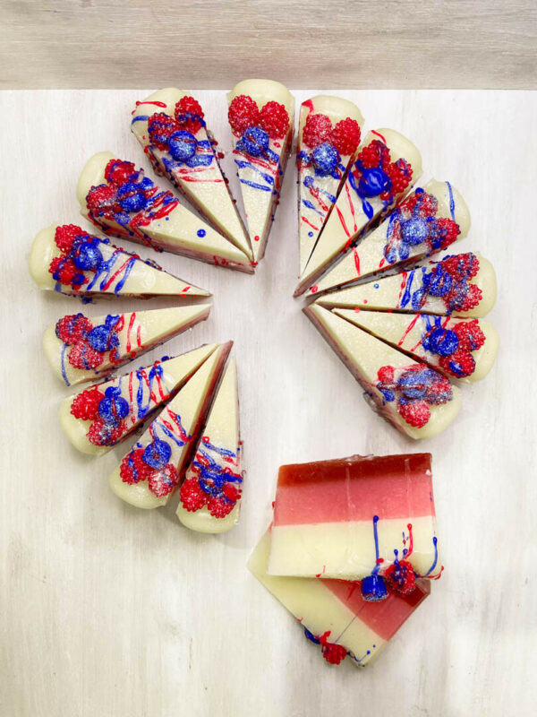 Σαπουνότουρτα Berries Soap Cake από τη Fiore Domenica, χειροποίητη με στρώσεις σε κόκκινο και κρεμ και διακόσμηση από ρεαλιστικά berries.