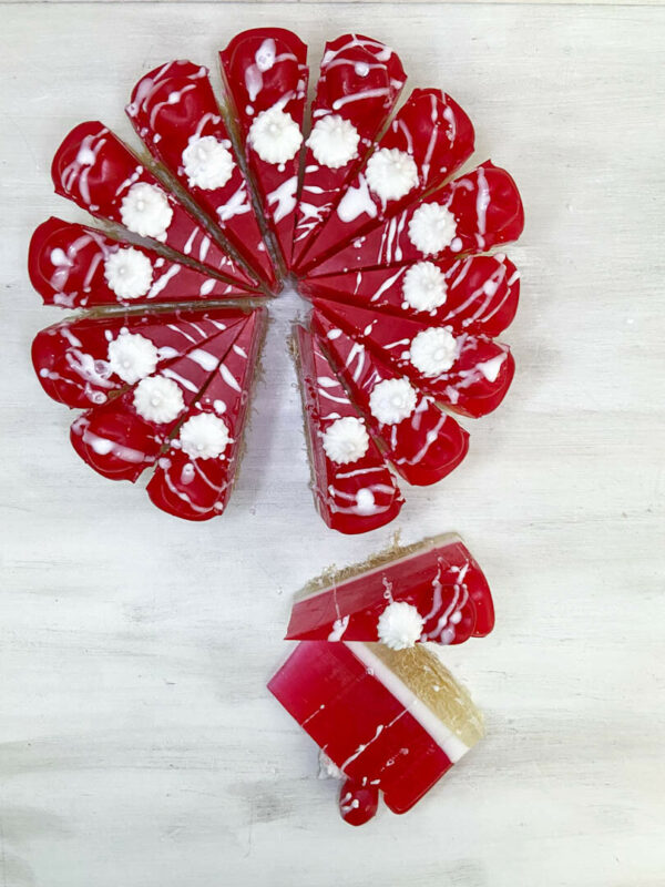 Χειροποίητη τούρτα σαπουνιού σε μορφή cheesecake με αποχρώσεις κερασιού και λευκού, διακοσμημένη με ρεαλιστικά στοιχεία και έντονο άρωμα κερασιού.